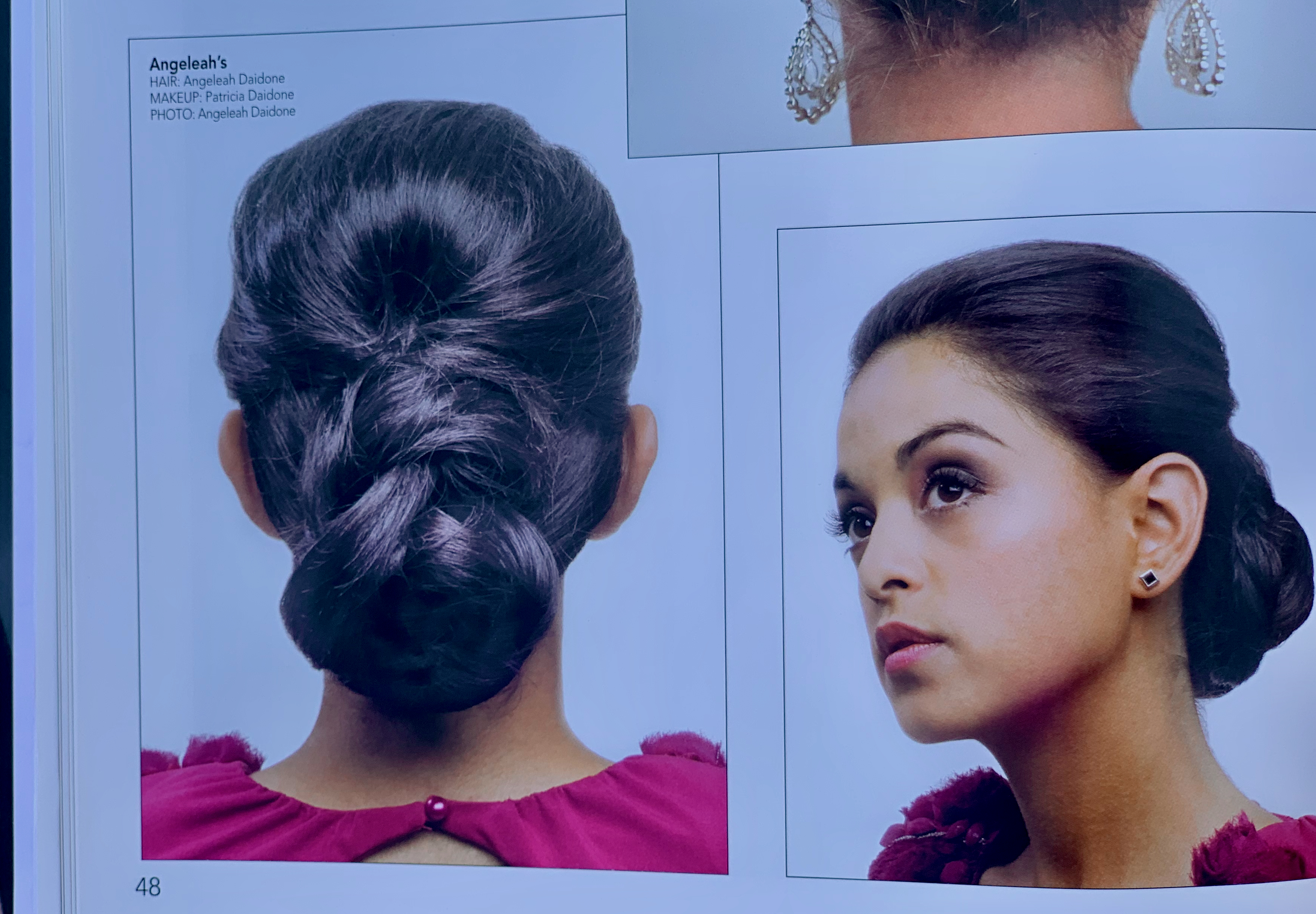 Page from the Inspire hairstyling book vol. 77, credited to Angeleah Daidone — back and side views of a sleek low chignon updo on a brunette model in a magenta top.